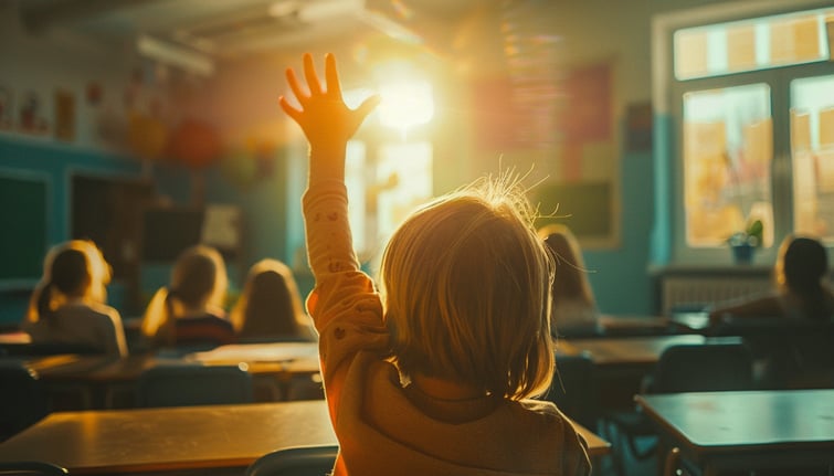 Young elementary school student raising their hand in the classroom
